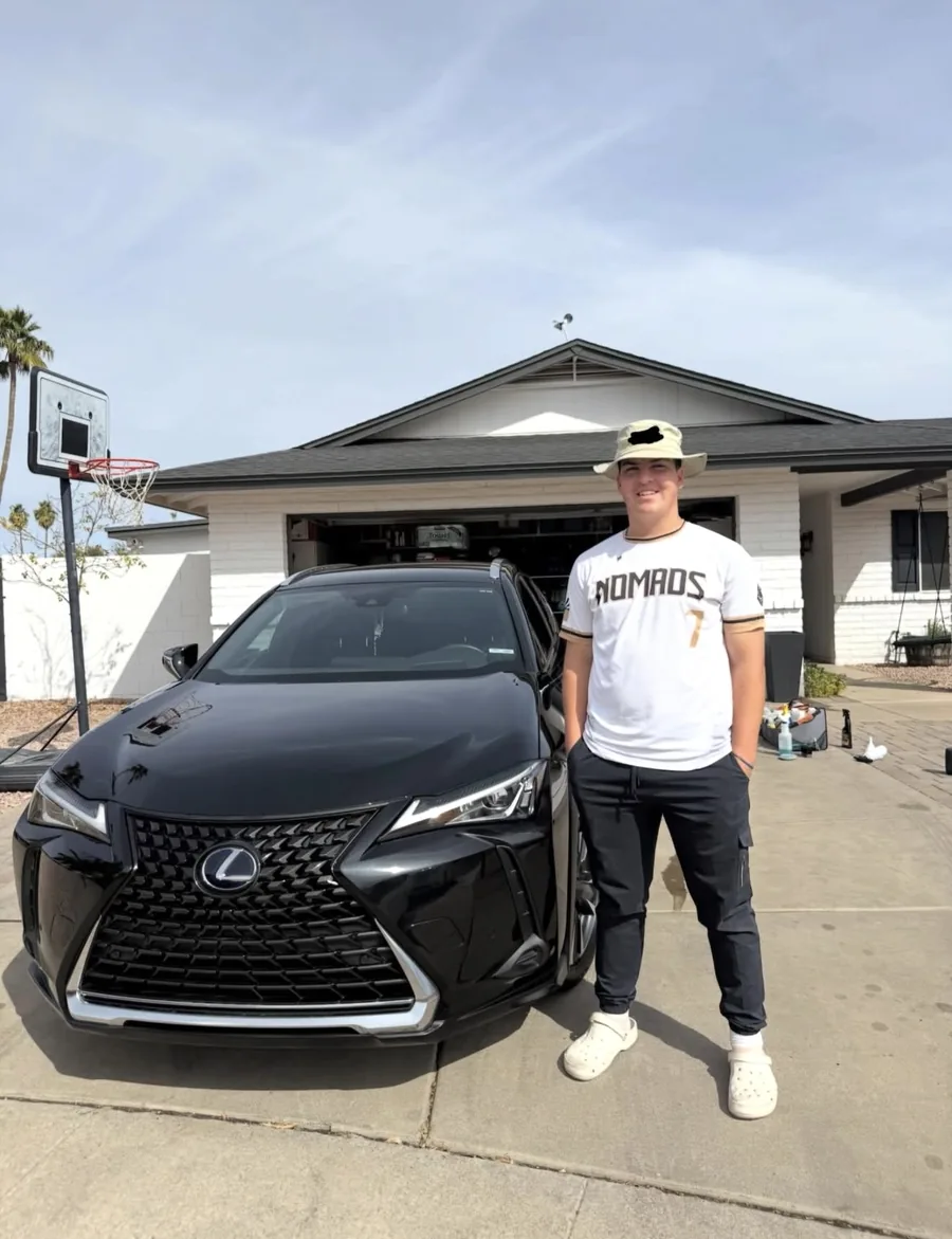 The owner of Smith Detail beside a freshly detailed black Lexus
